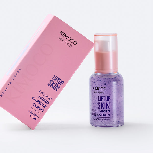 po środku różowe pudełko oparte o fioletową butelkę z pompką kosmetyku Lift-Up Skin Firming Micro Capsule Serum, na szarym tle.