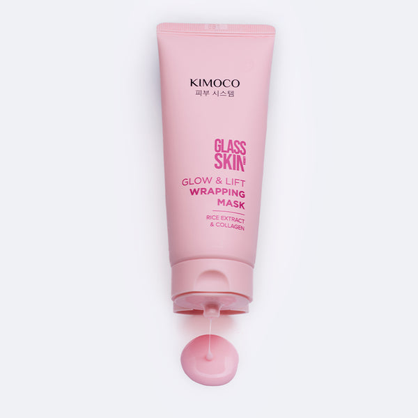 Różowa tubka kosmetyku Kimoco Glass Skin Glow & Lift Wrapping Mask z ekstraktem ryżowym i kolagenem, poniżej niewielka kropla wyciśniętego produktu, na białym tle.